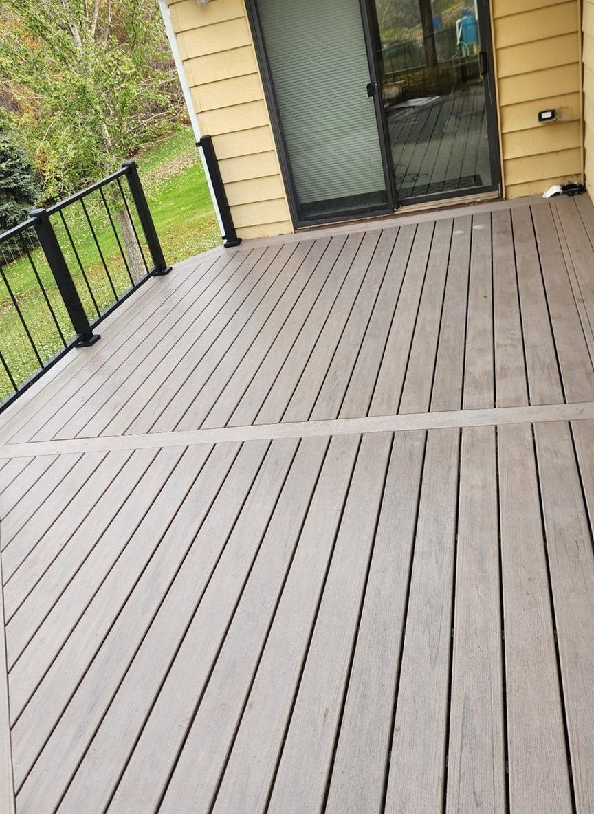 Composite deck with black aluminum railing, by New West Co