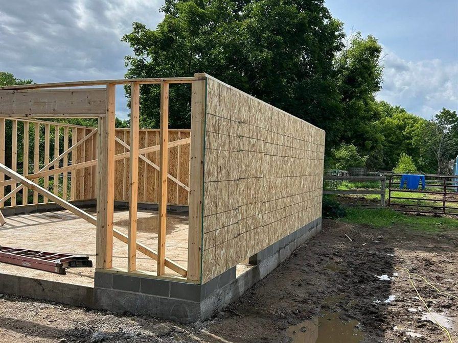Garage walls sheathed, by New West Co