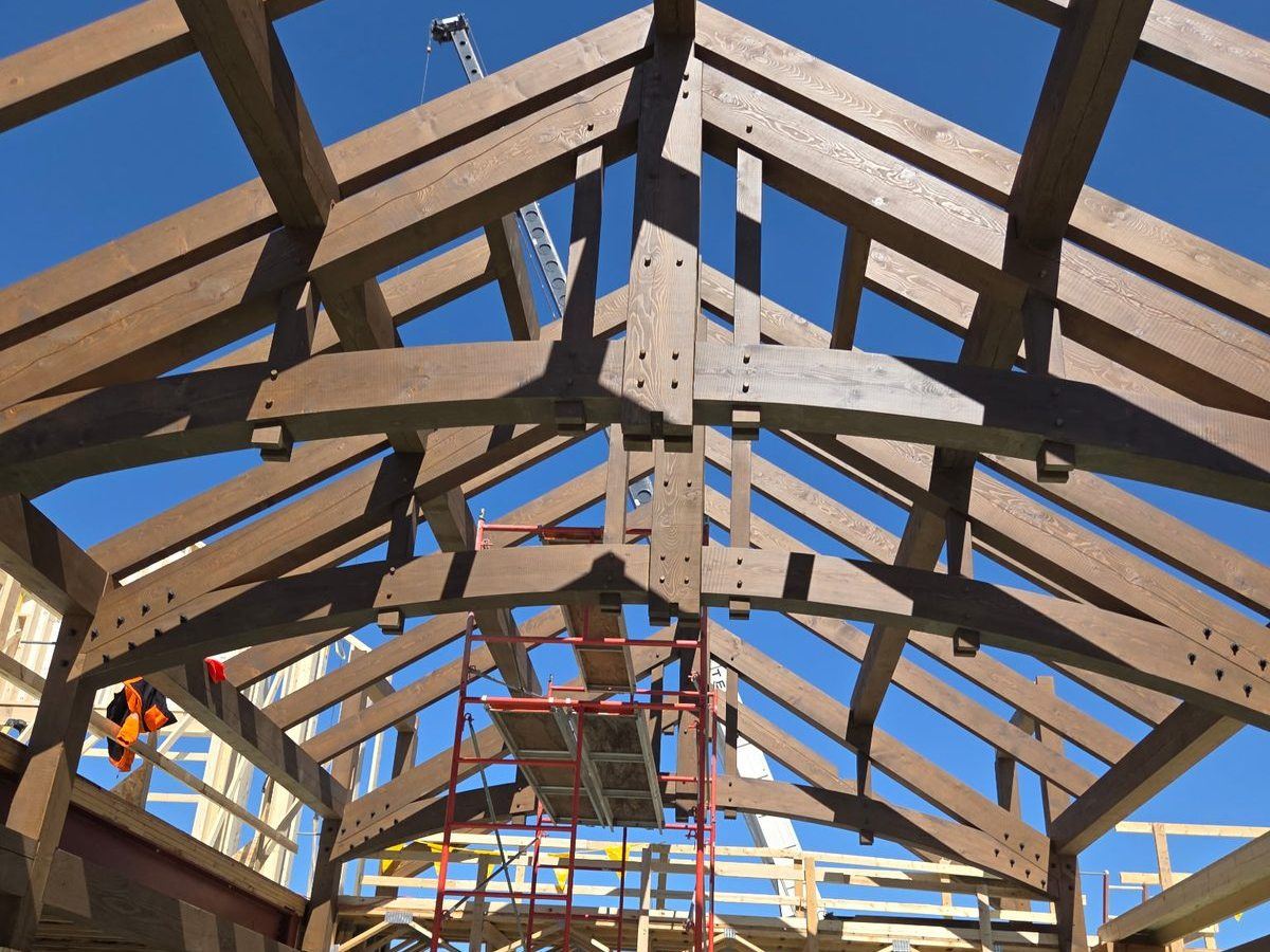 Timber trusses going up against a blue Colorado sky