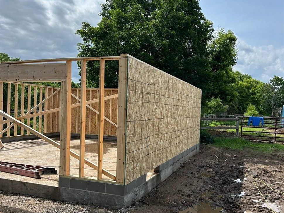 Garage walls sheathed, by New West Co